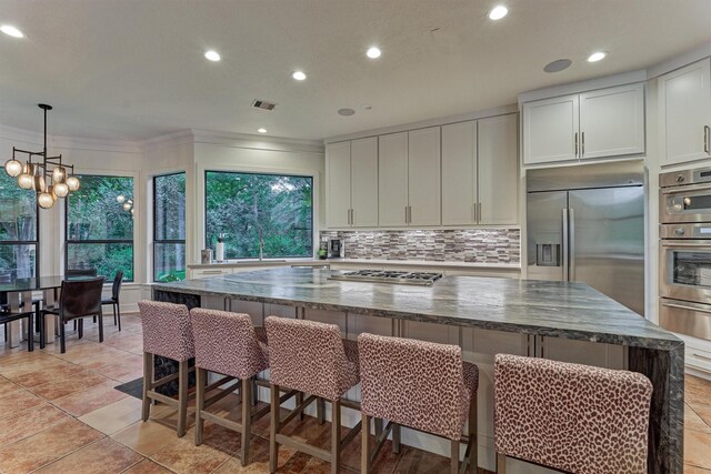 134 Trinity Oaks Ct, The Woodlands, TX 77381 - kitchen featuring appliances with stainless steel finishes, recessed lighting, a warming drawer, dark stone counters, and tasteful backsplash