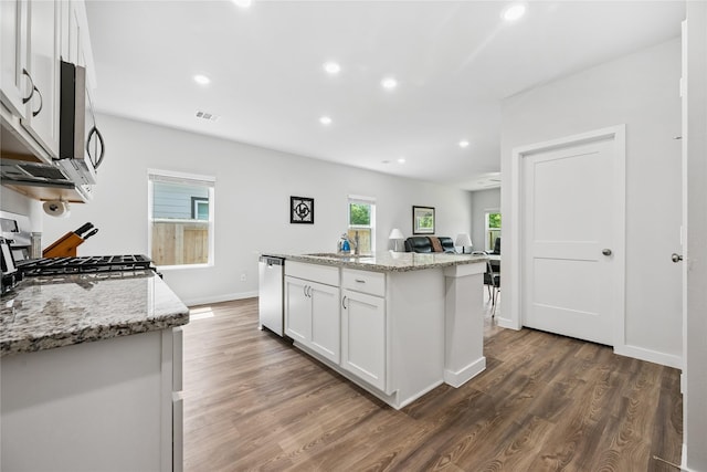 16934 Needlepoint Dr, Conroe, TX 77302 - kitchen featuring stainless steel dishwasher, wood finished floors, white cabinets, recessed lighting, and light stone countertops