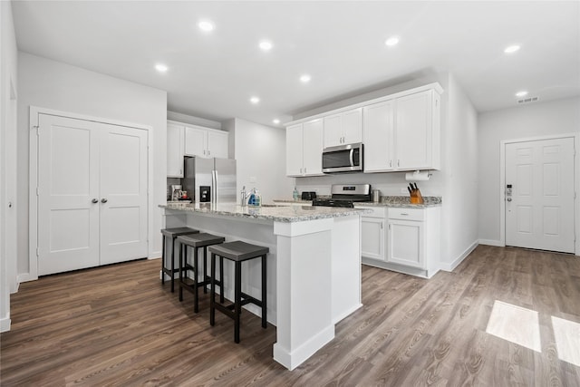 16934 Needlepoint Dr, Conroe, TX 77302 - kitchen with appliances with stainless steel finishes, wood finished floors, white cabinets, and recessed lighting