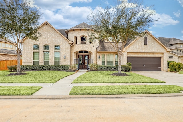 24115 Porte Toscana Ln, Richmond, TX 77406 - french country inspired facade with french doors, brick siding, concrete driveway, and a garage