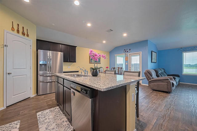 22618 Cremona Village Trl, Katy, TX 77449 - kitchen with appliances with stainless steel finishes, open floor plan, a breakfast bar area, dark wood-style flooring, and an island with sink