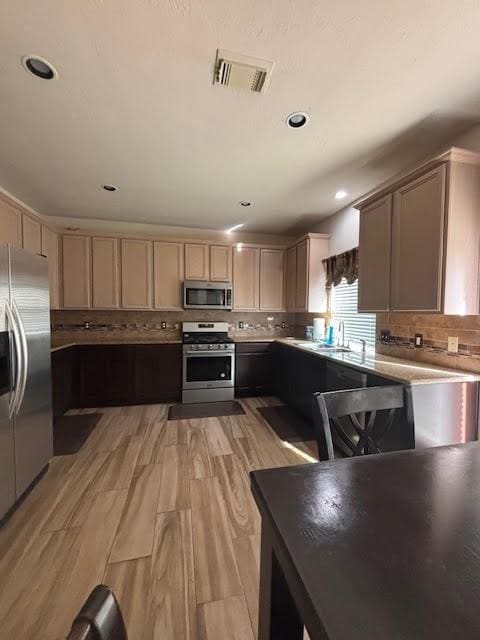 7126 Grants Hollow Ln, Richmond, TX 77407 - kitchen featuring stainless steel appliances, tasteful backsplash, light wood-type flooring, recessed lighting, and light countertops