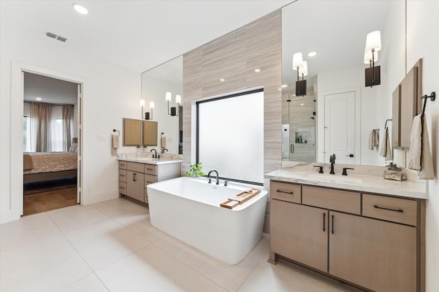 15714 Park Poetry Ct, Cypress, TX 77433 - ensuite bathroom featuring a stall shower, two vanities, a freestanding tub, tile patterned floors, and recessed lighting