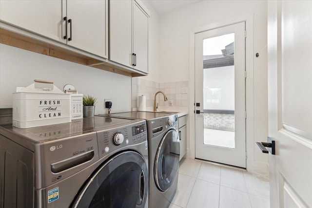 15714 Park Poetry Ct, Cypress, TX 77433 - washroom with washer and dryer, cabinet space, and light tile patterned floors