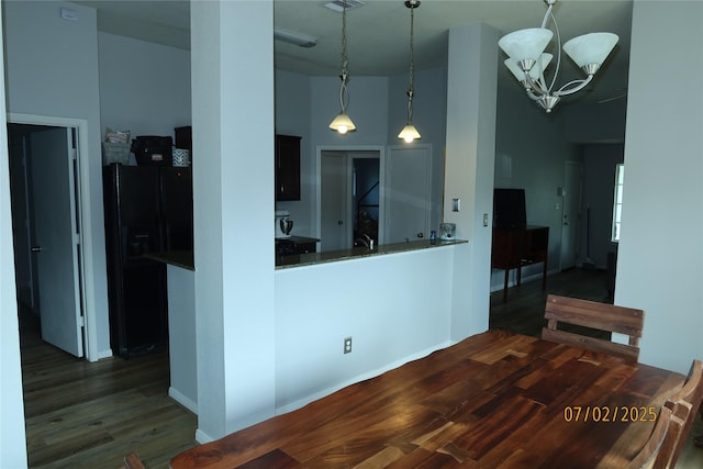 305 Duprie Dr, Brenham, TX 77833 - kitchen featuring black fridge, a chandelier, wood finished floors, pendant lighting, and a high ceiling