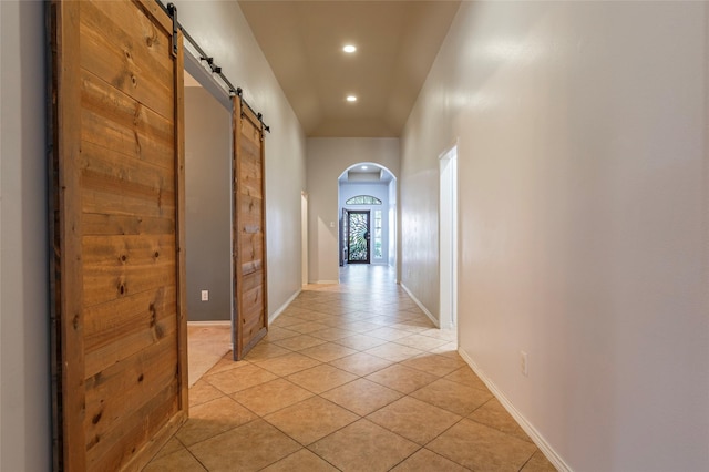 3211 Rock Brook Falls Ln, League City, TX 77573 - corridor featuring a barn door, arched walkways, light tile patterned floors, and recessed lighting
