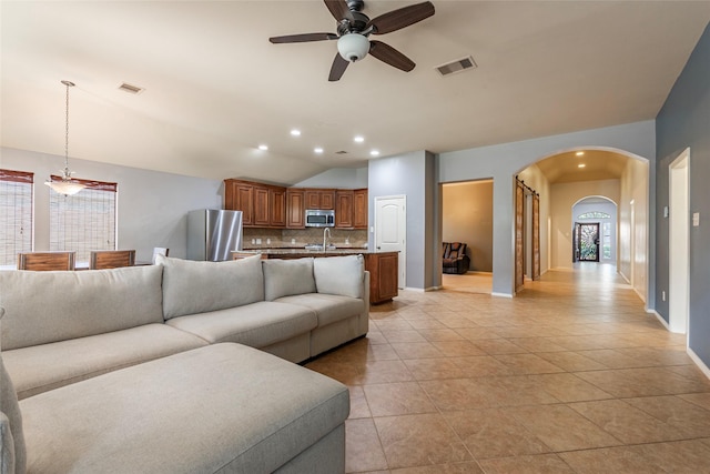 3211 Rock Brook Falls Ln, League City, TX 77573 - living room with arched walkways, a ceiling fan, vaulted ceiling, light tile patterned floors, and recessed lighting