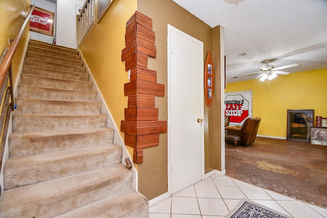 17010 Kings Walk Ln, Houston, TX 77070 - stairs with tile patterned flooring, ceiling fan, and a textured ceiling
