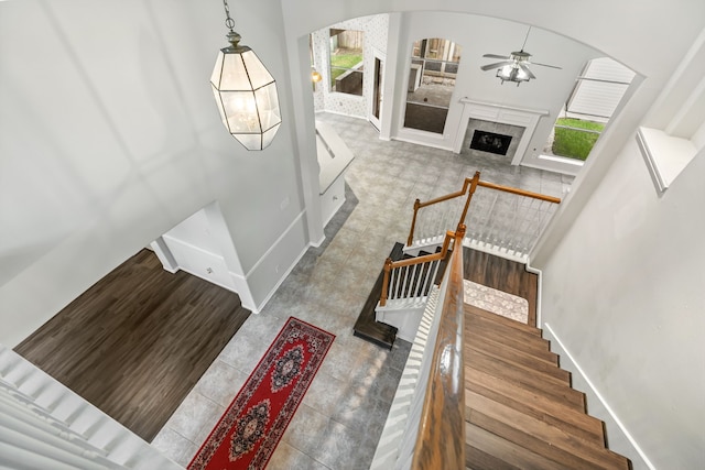 20907 Divellec Ln, Spring, TX 77388 - stairs with a ceiling fan, arched walkways, tile patterned floors, and a fireplace