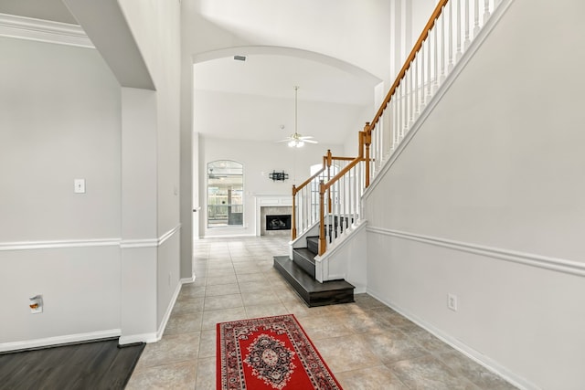 20907 Divellec Ln, Spring, TX 77388 - foyer with a ceiling fan, arched walkways, stairs, a towering ceiling, and light tile patterned floors