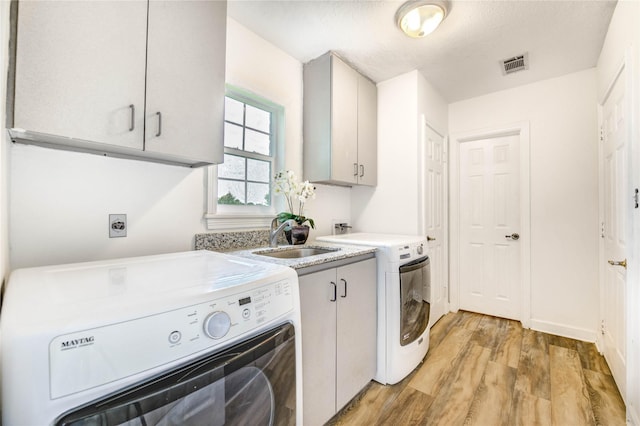 6606 Williams School Ct, Needville, TX 77461 - laundry area with cabinet space, light wood-type flooring, and washer and clothes dryer