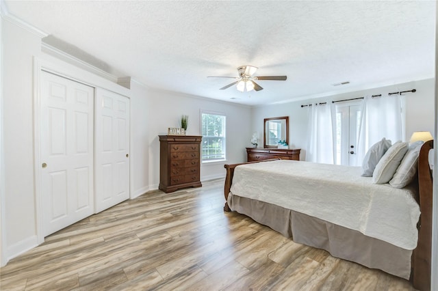 6606 Williams School Ct, Needville, TX 77461 - bedroom with light wood-style floors, crown molding, a closet, ceiling fan, and a textured ceiling