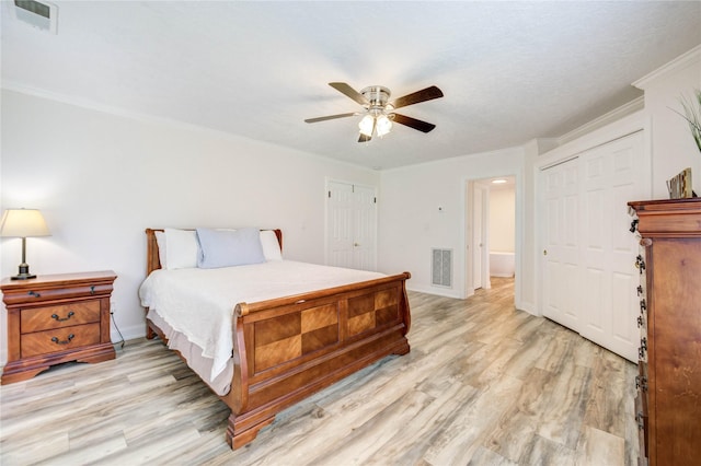 6606 Williams School Ct, Needville, TX 77461 - bedroom with light wood-type flooring, ornamental molding, a ceiling fan, and multiple closets