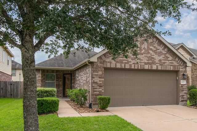 14039 Embry Stone Ln, Houston, TX 77047 - view of front of house with brick siding, a garage, a shingled roof, and driveway
