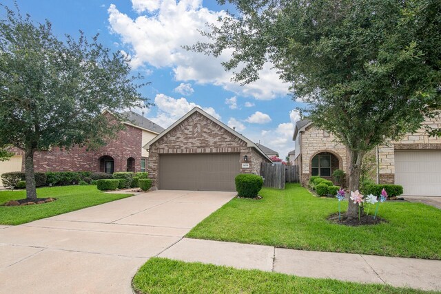 14039 Embry Stone Ln, Houston, TX 77047 - view of front of property featuring driveway, a garage, brick siding, stone siding, and a chimney