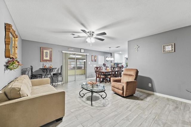 14018 Duncannon Dr, Houston, TX 77015 - living area with a ceiling fan, a textured ceiling, light wood-type flooring, and a chandelier