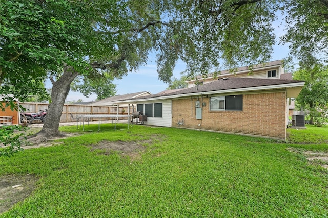 14018 Duncannon Dr, Houston, TX 77015 - back of property featuring a trampoline, a fenced backyard, brick siding, and roof with shingles