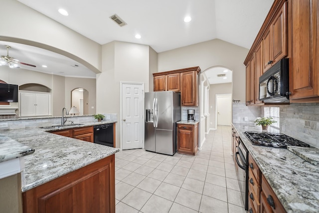 3343 Summerwood Ln, Pearland, TX 77584 - kitchen with black appliances, ceiling fan, decorative backsplash, brown cabinetry, and lofted ceiling
