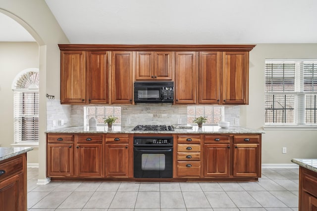 3343 Summerwood Ln, Pearland, TX 77584 - kitchen featuring black appliances, decorative backsplash, arched walkways, and light tile patterned flooring