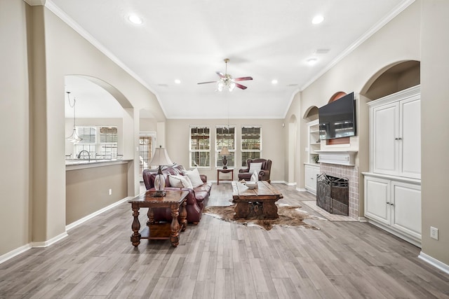 3343 Summerwood Ln, Pearland, TX 77584 - living area featuring ceiling fan, ornamental molding, a brick fireplace, light wood finished floors, and recessed lighting