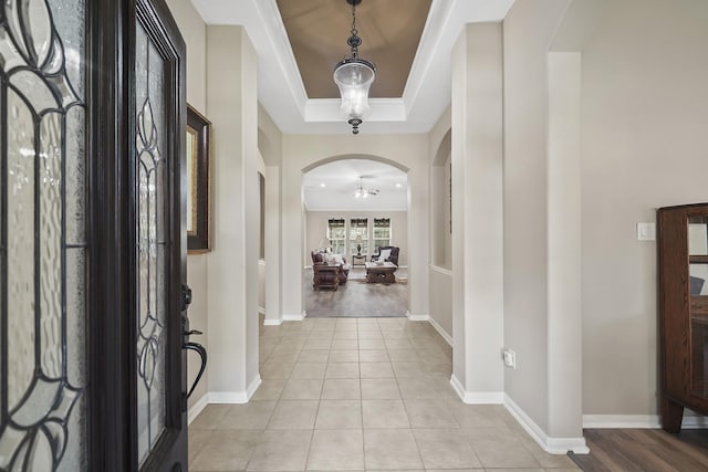 3343 Summerwood Ln, Pearland, TX 77584 - foyer entrance with arched walkways, a raised ceiling, ornamental molding, and light tile patterned floors