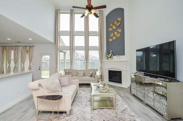 3707 Brampton Island Dr, Katy, TX 77494 - living area with ceiling fan, wood finished floors, plenty of natural light, a glass covered fireplace, and a high ceiling
