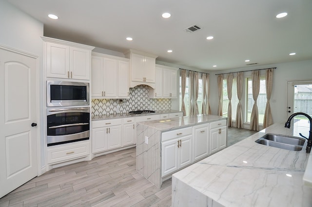 3707 Brampton Island Dr, Katy, TX 77494 - kitchen featuring stainless steel appliances, a kitchen island, decorative backsplash, white cabinetry, and recessed lighting