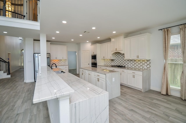 3707 Brampton Island Dr, Katy, TX 77494 - kitchen with a large island, stainless steel appliances, light wood-style flooring, backsplash, and recessed lighting