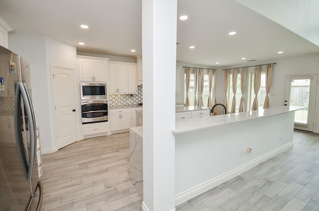 3707 Brampton Island Dr, Katy, TX 77494 - kitchen featuring stainless steel appliances, recessed lighting, decorative backsplash, white cabinets, and light wood finished floors