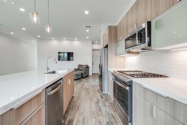 4402 Santorini Ln, Houston, TX 77045 - kitchen featuring stainless steel appliances, modern cabinets, light brown cabinets, open floor plan, and recessed lighting