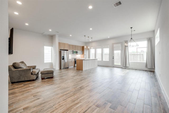 4402 Santorini Ln, Houston, TX 77045 - living room featuring light wood-style flooring, a chandelier, and recessed lighting