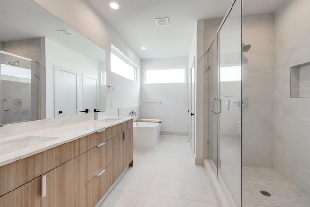 4402 Santorini Ln, Houston, TX 77045 - full bathroom with a stall shower, double vanity, a freestanding tub, tile patterned flooring, and recessed lighting