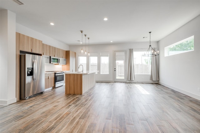 4402 Santorini Ln, Houston, TX 77045 - kitchen featuring appliances with stainless steel finishes, a chandelier, light wood finished floors, light countertops, and recessed lighting