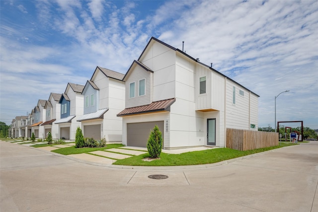 4402 Santorini Ln, Houston, TX 77045 - contemporary home with an attached garage, a residential view, driveway, a metal roof, and a standing seam roof