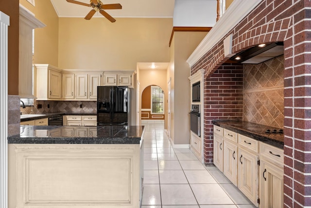 5802 Ashmere Ln, Spring, TX 77379 - kitchen with black appliances, cream cabinets, light tile patterned floors, a high ceiling, and backsplash