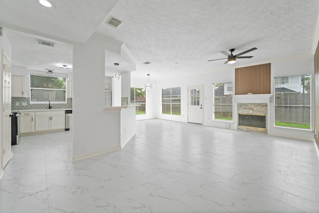 13611 Ortega Ln, Houston, TX 77083 - unfurnished living room with a ceiling fan, healthy amount of natural light, a fireplace, light marble finish flooring, and ornamental molding