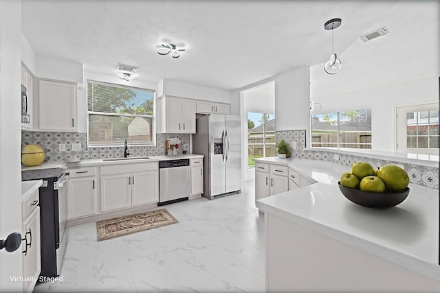 13611 Ortega Ln, Houston, TX 77083 - kitchen with appliances with stainless steel finishes, light marble finish flooring, decorative backsplash, and white cabinetry