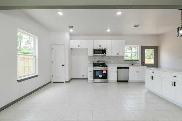 8306 E Tidwell Rd, Houston, TX 77028 - kitchen featuring stainless steel appliances, light countertops, white cabinetry, and recessed lighting