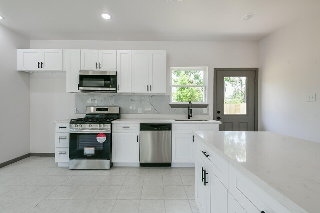 8306 E Tidwell Rd, Houston, TX 77028 - kitchen with stainless steel appliances, light countertops, tasteful backsplash, recessed lighting, and white cabinetry