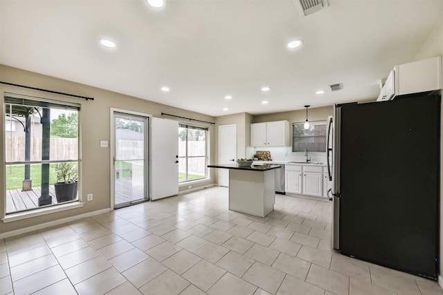 2322 Old Oak Ln, Kingwood, TX 77339 - kitchen featuring appliances with stainless steel finishes, a kitchen island, white cabinetry, light tile patterned floors, and recessed lighting
