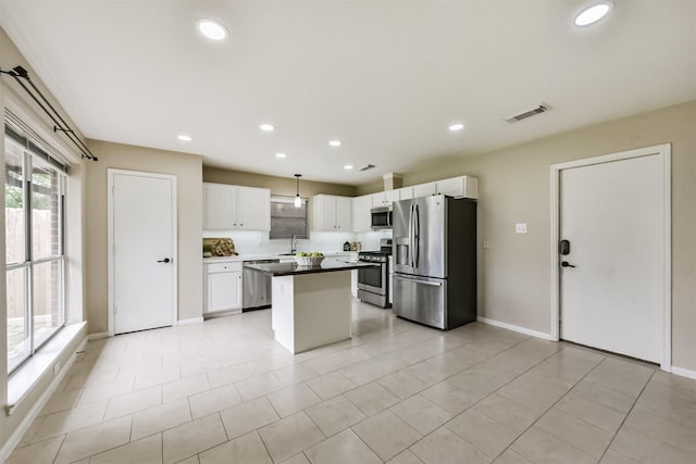 2322 Old Oak Ln, Kingwood, TX 77339 - kitchen featuring stainless steel appliances, white cabinetry, a kitchen island, recessed lighting, and light tile patterned floors