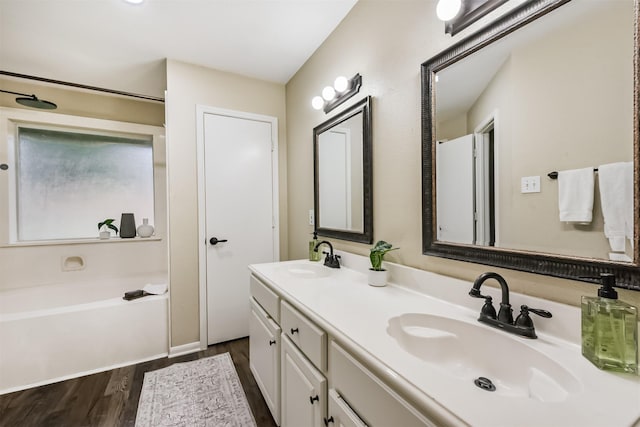 2322 Old Oak Ln, Kingwood, TX 77339 - bathroom with double vanity, wood finished floors, and a bath