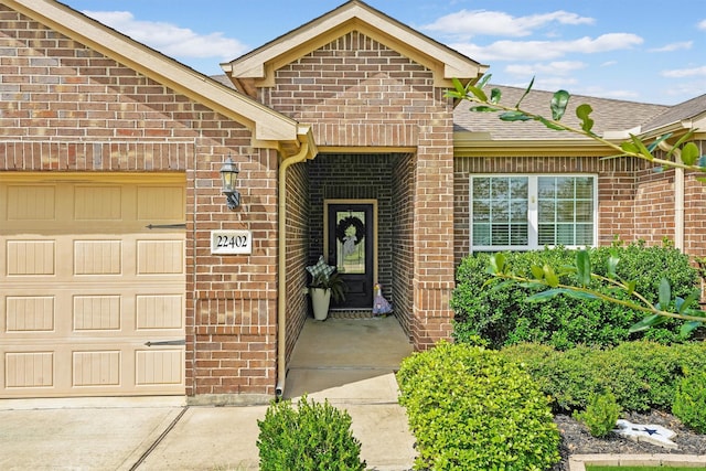 22402 Threefold Ridge Dr, Hockley, TX 77447 - doorway to property with brick siding, a garage, and a shingled roof