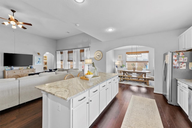 22402 Threefold Ridge Dr, Hockley, TX 77447 - kitchen with arched walkways, ceiling fan, stainless steel appliances, a center island, and white cabinets