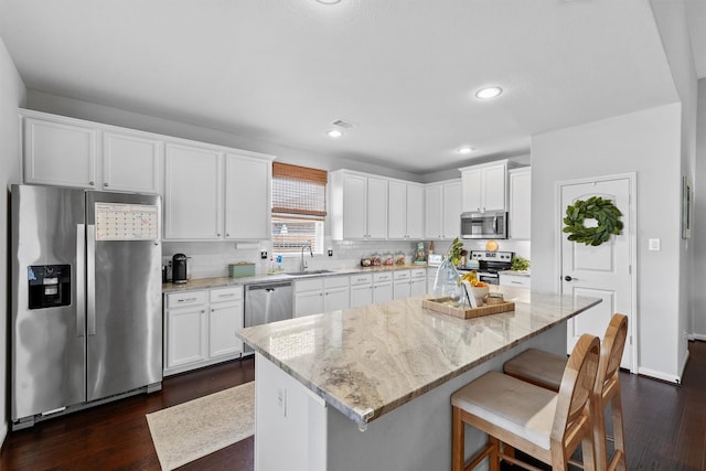 22402 Threefold Ridge Dr, Hockley, TX 77447 - kitchen featuring appliances with stainless steel finishes, dark wood-style flooring, white cabinetry, light stone counters, and recessed lighting