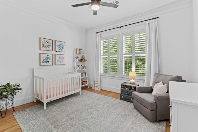 1603 Columbia St, Houston, TX 77008 - bedroom featuring crown molding, a crib, light wood-type flooring, and a ceiling fan