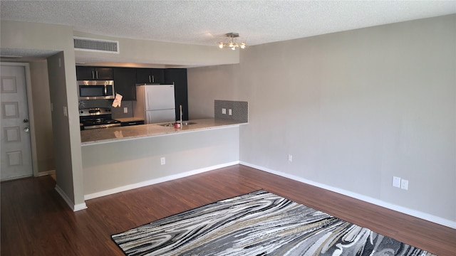 2818 S Bartell Dr Unit 13, Houston, TX 77054 - kitchen with stainless steel appliances, dark cabinets, dark wood-style flooring, light countertops, and a textured ceiling