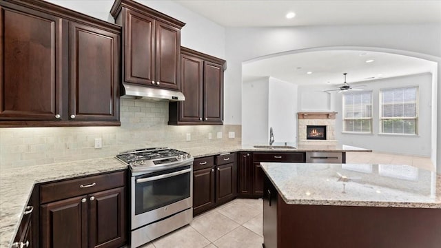 4627 Western Brook Dr, Spring, TX 77388 - kitchen featuring gas stove, under cabinet range hood, arched walkways, a ceiling fan, and recessed lighting