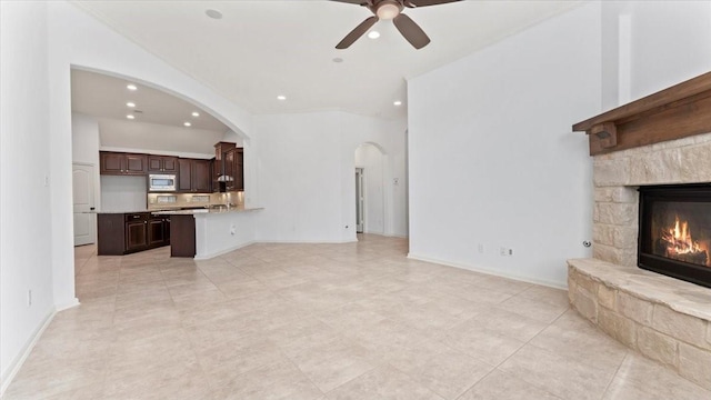 4627 Western Brook Dr, Spring, TX 77388 - unfurnished living room featuring ceiling fan, recessed lighting, arched walkways, a fireplace, and light tile patterned flooring
