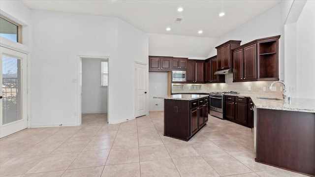 4627 Western Brook Dr, Spring, TX 77388 - kitchen with appliances with stainless steel finishes, open shelves, decorative backsplash, a center island, and light stone countertops